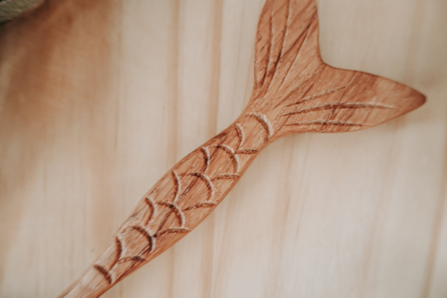 Wooden spoon with engraved design on a wooden surface