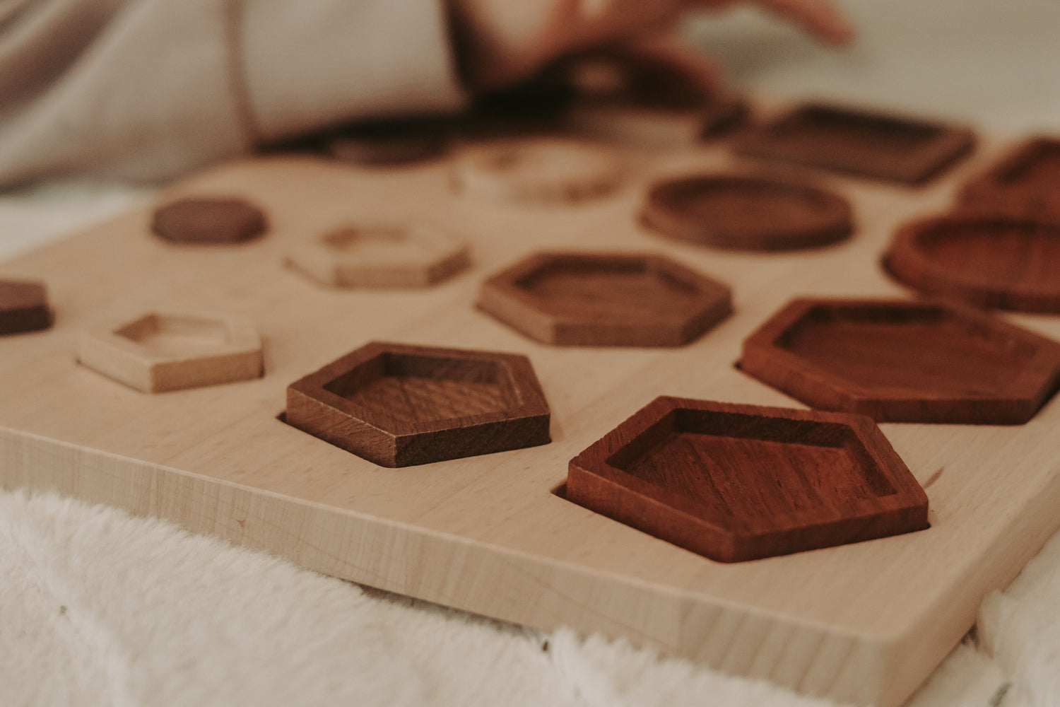 Wooden puzzle with various shaped wooden pieces on a wooden board.